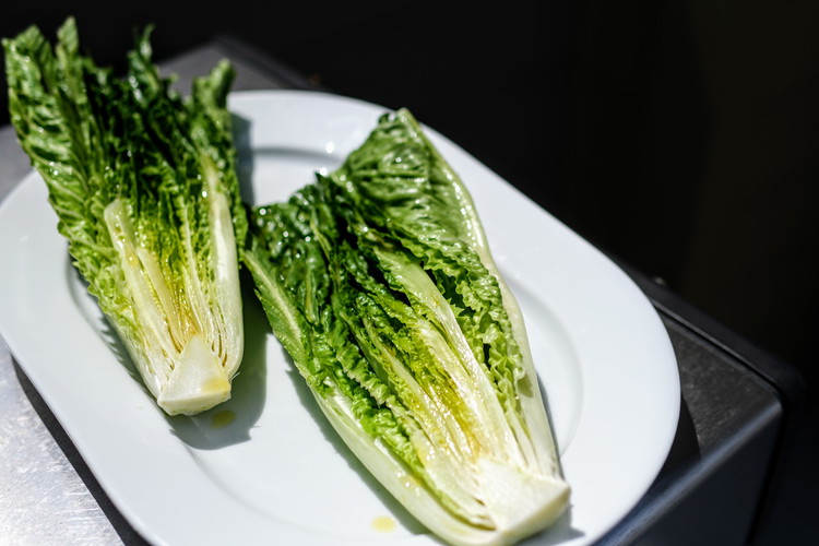 Image of Wash Romaine Lettuce well.  Cut a thin slice off of the base.  Avoid overcutting the base so that the leaves do not come apart. For presentation you may also want to trim the top in a straight line though this...