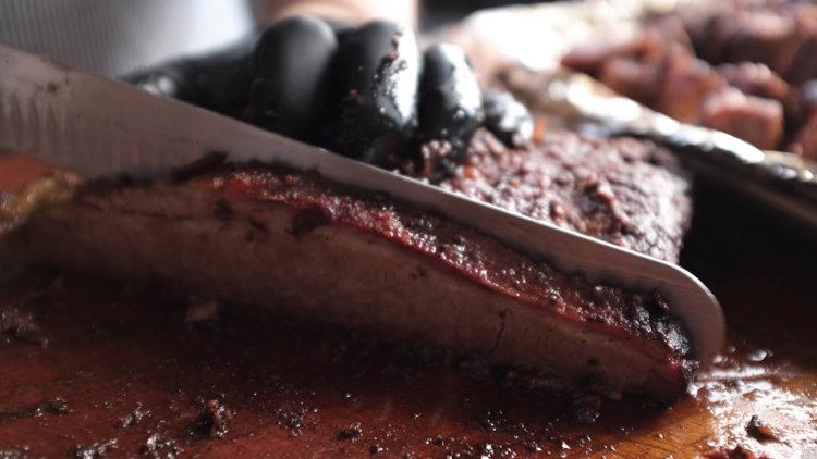 Image of While the sauce sets up, slice the brisket across the...