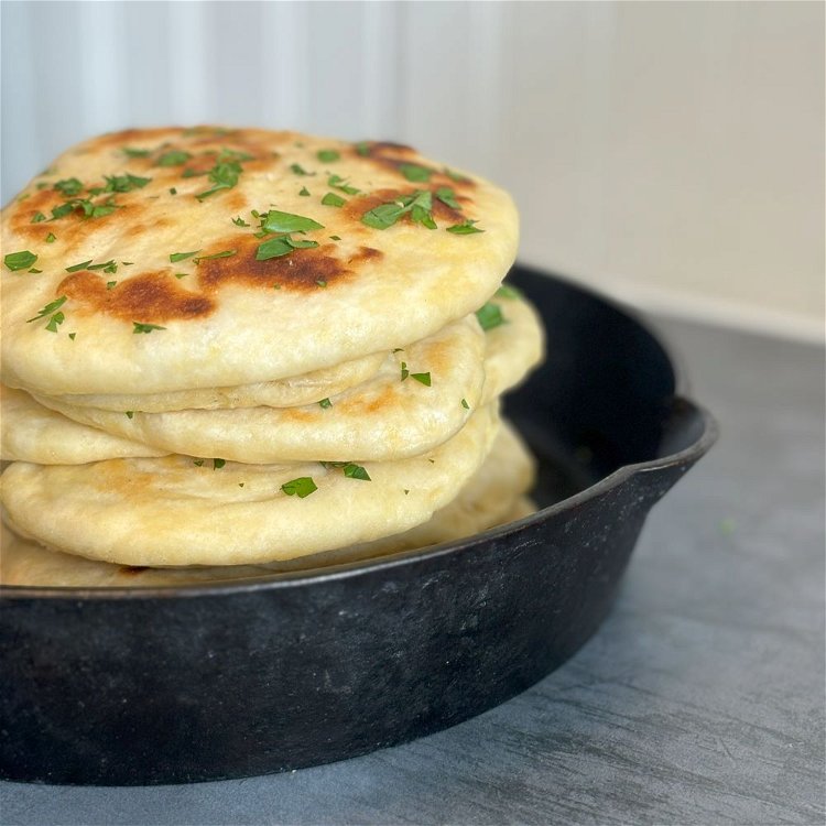 Image of Brush naan with more garlic butter before serving. Garnish with...