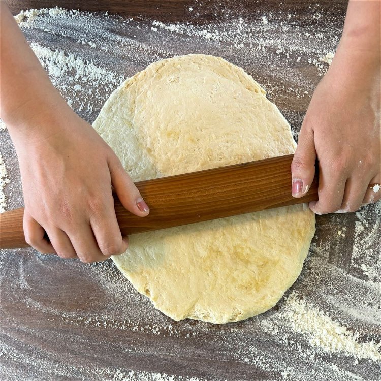 Image of Using a rolling pin, flatten each piece of dough into...