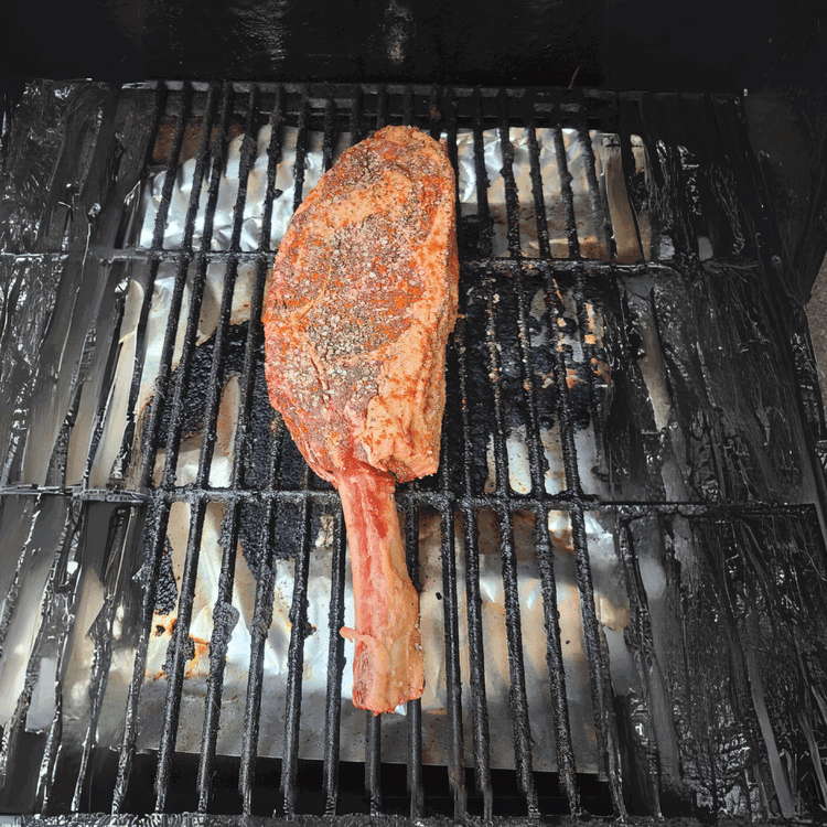 Image of Place the seasoned steak on the smoker grate. Insert a meat thermometer into the thickest part of the steak if you have one, otherwise use an instant read thermometer. 
