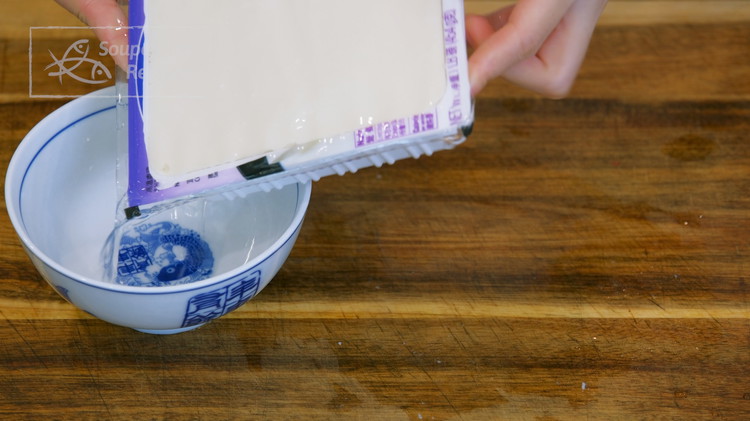 Image of Open the silken tofu package and pour out the excess water.