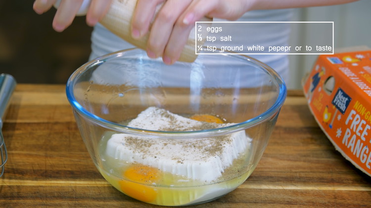 Image of Add the tofu, 2 eggs, 1/4 tsp salt, and 1/4 tsp ground white pepper to a big mixing bowl. Use a whisk to break and stir the tofu and eggs as fine as possible.