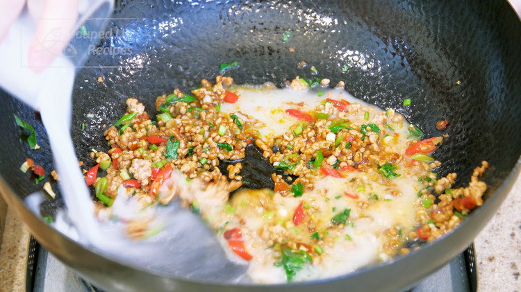 Image of Quickly mix 3/4 cup of water with 1.5 tsp of cornstarch and pour it into the wok. Stir until the sauce thickens.