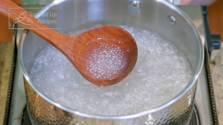 Image of After 10 minutes, the sago becomes translucent but still has a white hard center, which looks a lot like caviar. Put on the lid and let the pearls sit in the hot water for 15 minutes. The rest of the heat will continue to cook them until done.