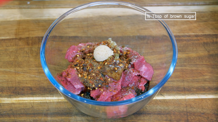 Image of Cut the beef into bite-size pieces and place it into a big mixing bowl. Add grated garlic, grated ginger, fermented bean curd, soy sauce, dark soy sauce, oyster sauce, salt, black pepper, five-spice powder, Sichuan Peppercorn powder, chili flake, and brown...