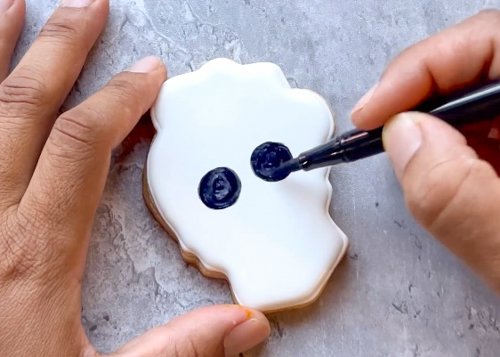 Image of Use your black edible marker to draw circles for the skull eye holes. This can be done with royal icing, but we found that using an edible marker allows more precision. 