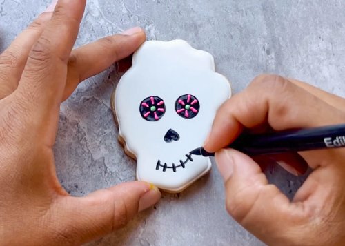 Image of Use your edible marker to draw a nose and mouth onto your sugar skull as shown. 