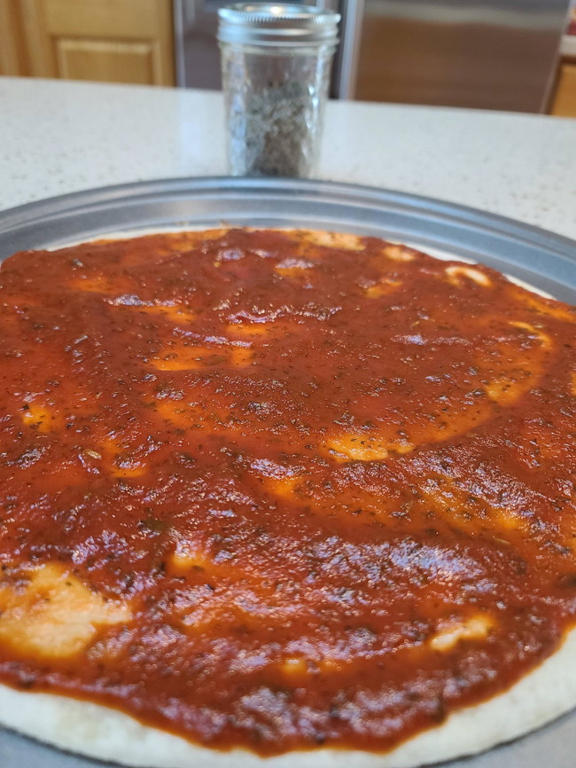 Uncooked pizza with sauce