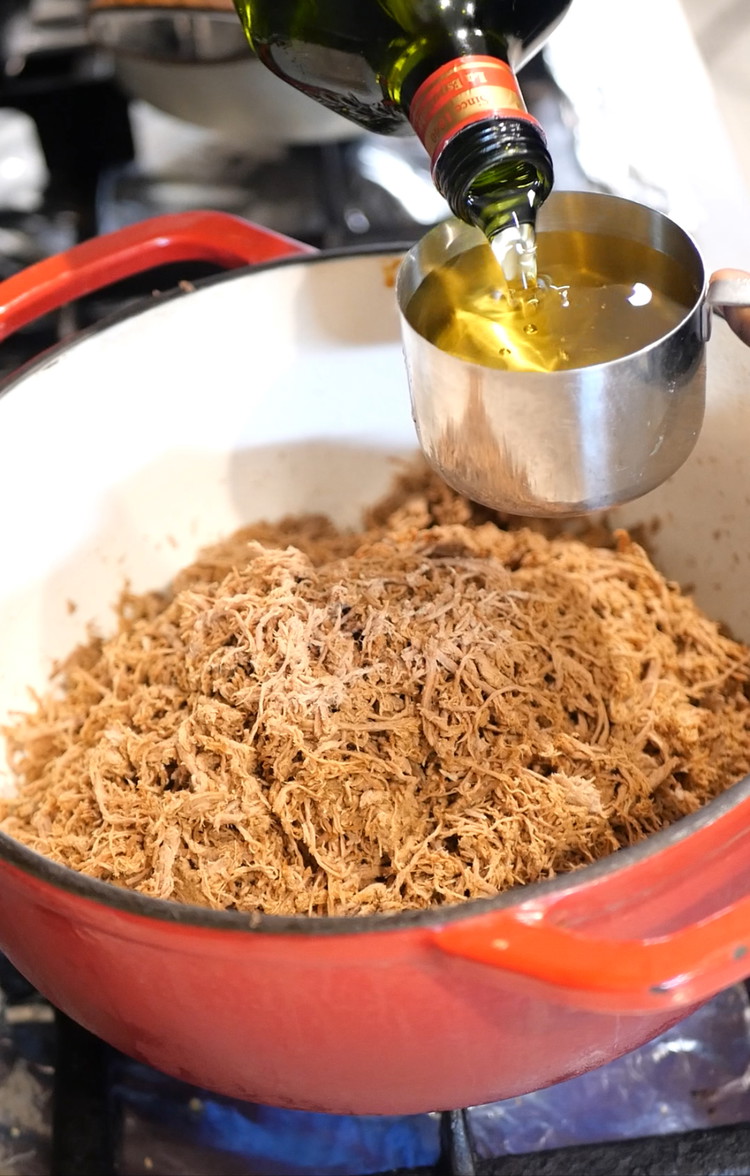 Image of Transfer shredded beef into a pot and add 3 to 4 cups of oil. 