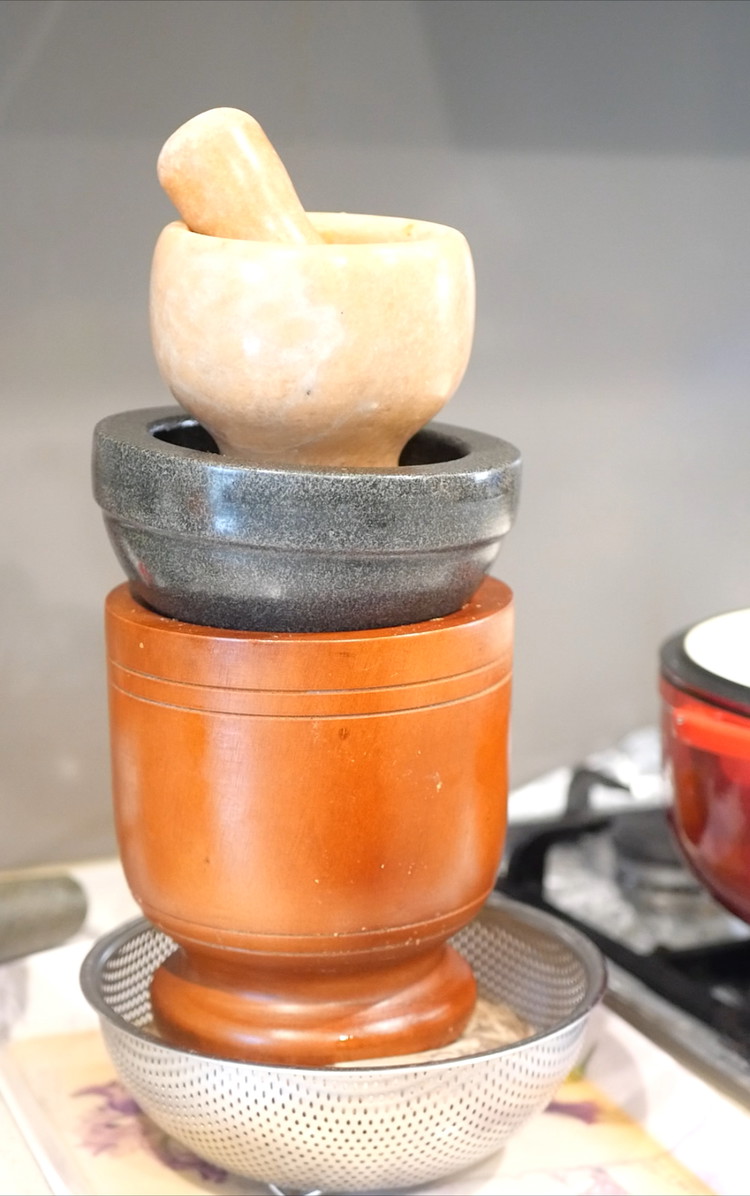 Image of Add the dambu into a milk bag or cheese cloth. Place a weighted object on the dambu to help extract the excess oil. 