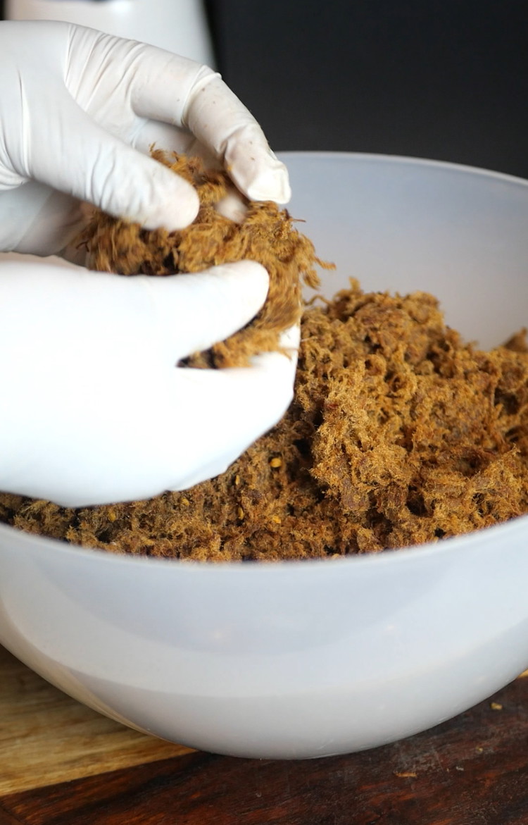 Image of After extracting the oil, gently run your fingers through the dambu and pull at the threads of beef to create a floss-like texture.