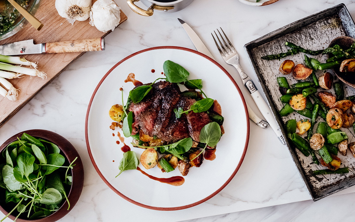 Seared Cap of Ribeye Steak with Roasted Potatoes, Snap Peas, Asparagus and Wine Reduction