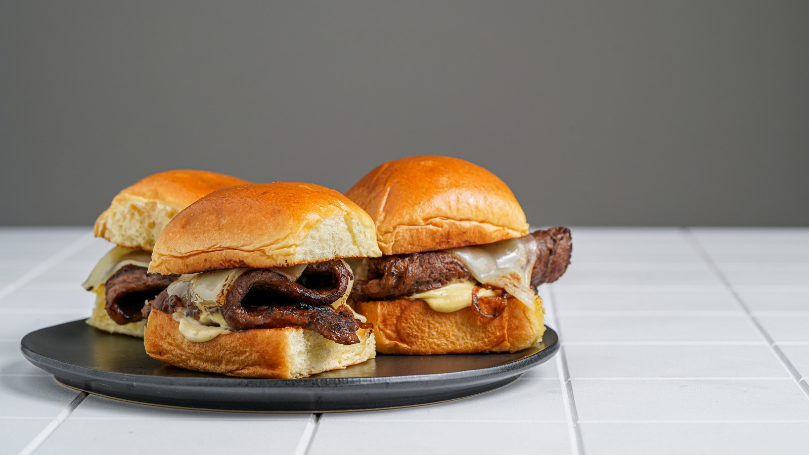 Image of Cheesesteak Sliders with Caramelized Onions and Dijon Aioli