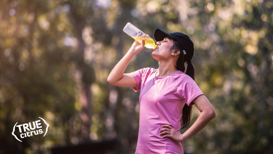 Female runner refreshing herself with a bottle of True Lemon infused electrolyte beverage
