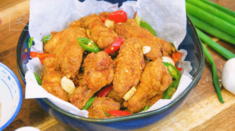 Image of Remove the chicken wings from the oil and set them aside. Pour out most of the frying oil from the wok, but leave 2 tsp behind. Add the garlic, ginger, red, and green chili slices. Stir over medium heat for...