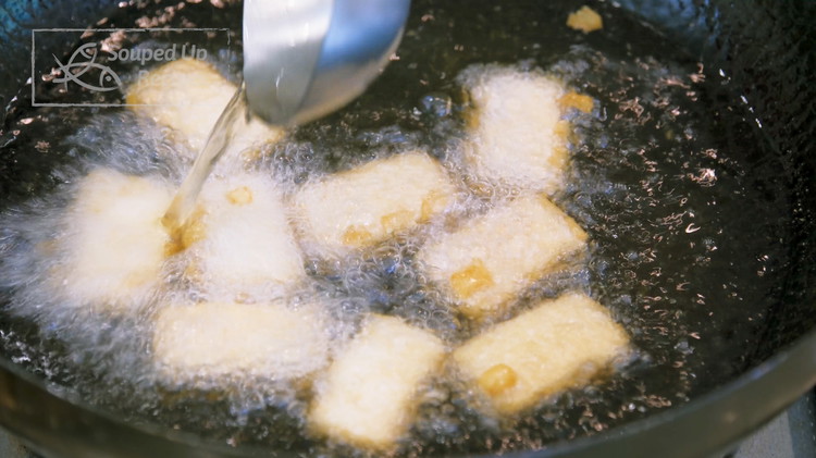 Image of Heat 1.5 cups of oil to 380℉ / 193℃. Take the tofu and add to the oil. Make sure the furry side faces down because the bottom where it contacts the rack doesn't have the mycelium, so it will stick...