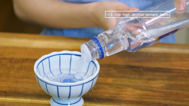 Image of Pour 1/3 cup of high-alcohol content liqueur into a bowl. I was supposed to use baijiu, but I couldn't find it around where I live, so I use vodka as a replacement. Whisky and Rum will also work.