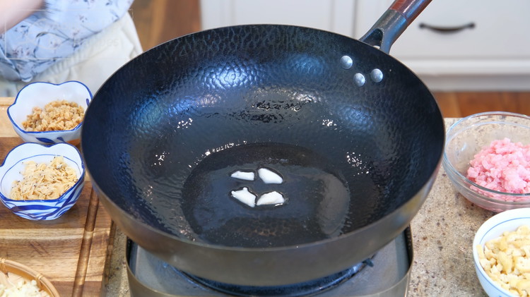 Image of Heat the wok over high heat until smoking hot. Add pork lard and let it melt. If you don't like animal fat, use vegetable oil instead.
