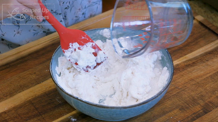 Image of Add the salt to the water and bring it to a boil, then immediately pour it into the flour and stir simultaneously. The water must be as hot as possible to ensure the dough's elasticity.