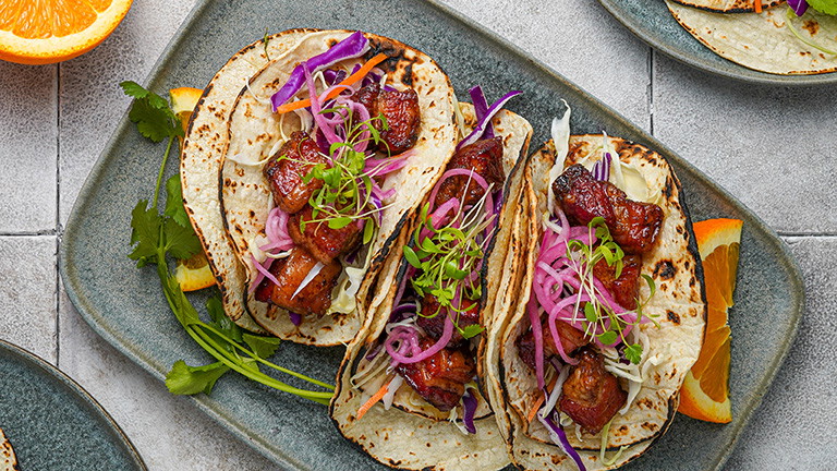 Image of Crispy Smoked Kurobuta Pork Belly Tacos with Serrano-Orange Glaze and Pickled Red Onions