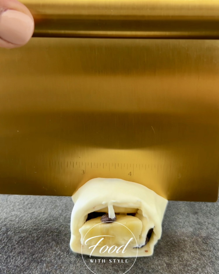 Image of Pokrój rulon na kawałki o szerokości około 4 cm i ułóż je cięciem do dołu na blaszce wyłożonej papierem do pieczenia.