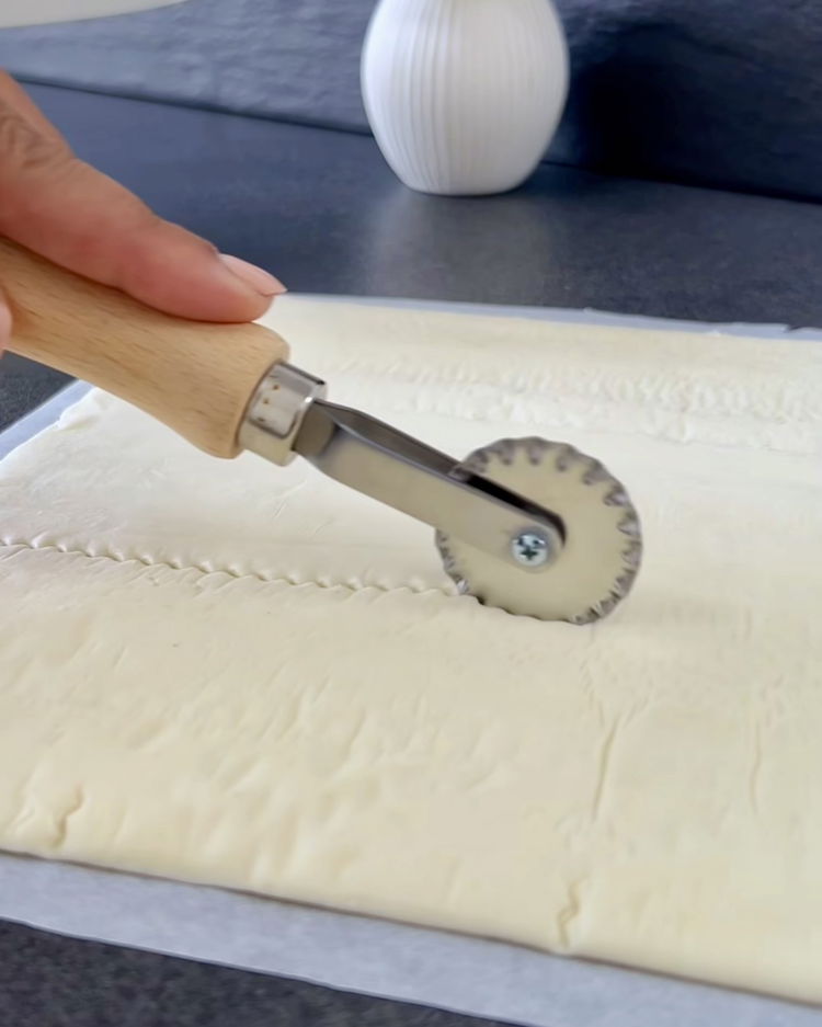 Image of Desfaceți aluatul fraged și tăiați-l în 12 pătrate egale.