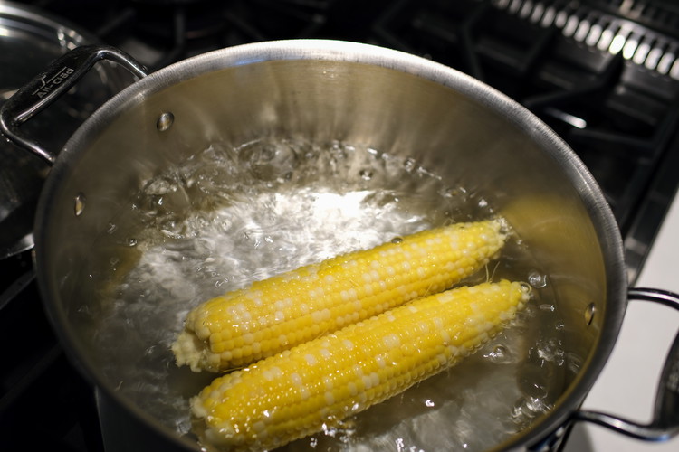 Image of Once water is boiling add corn, put the lid on the pot and boil for 7 minutes.