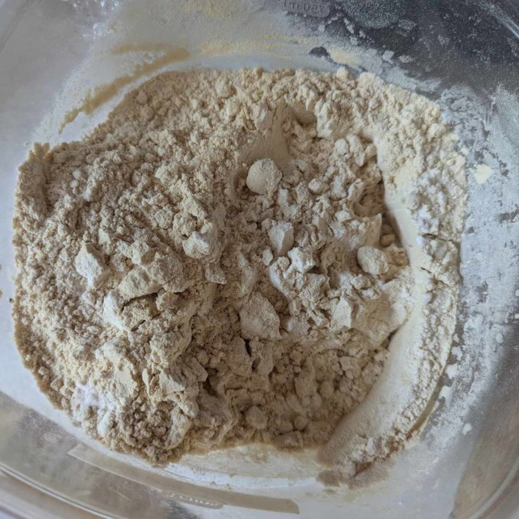 Image of In a separate bowl, mix together all of the dry ingredients: flour, protein powder, baking soda, baking powder, chocolate chips, and cinnamon.