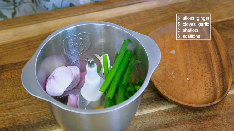 Image of Add 3 slices of ginger, 5 cloves of garlic, 2 shallots, and 3 scallions into a blender and chop finely.