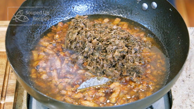Image of Add the meigancai to the pork belly and continue to braise for 1 more hour or until the pork is tender.
