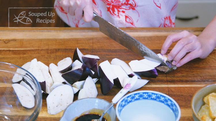 Image of Use the roll-cutting technique to cut the eggplants into a size slightly bigger than the potatoes because eggplant shrinks after cooking.