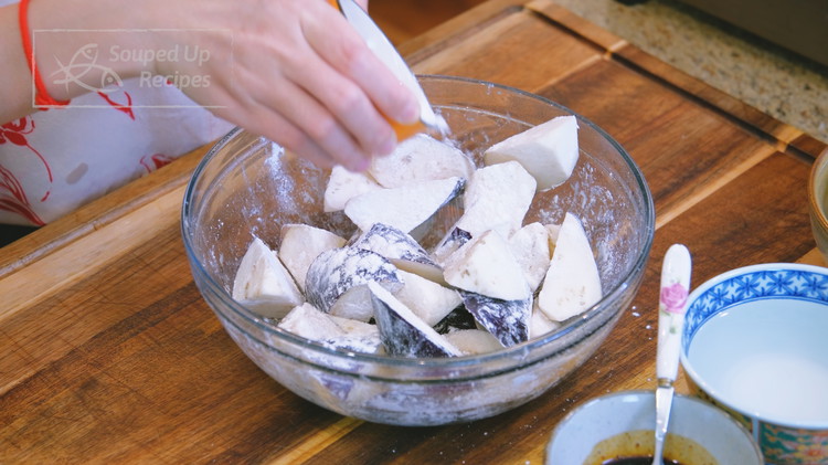 Image of Add the eggplant to a big bowl. Use a spray bottle to spray some water to wet the surface of the eggplant. Sprinkle 3 Tbsps cornstarch in batches and toss thoroughly until the eggplant is coated well.