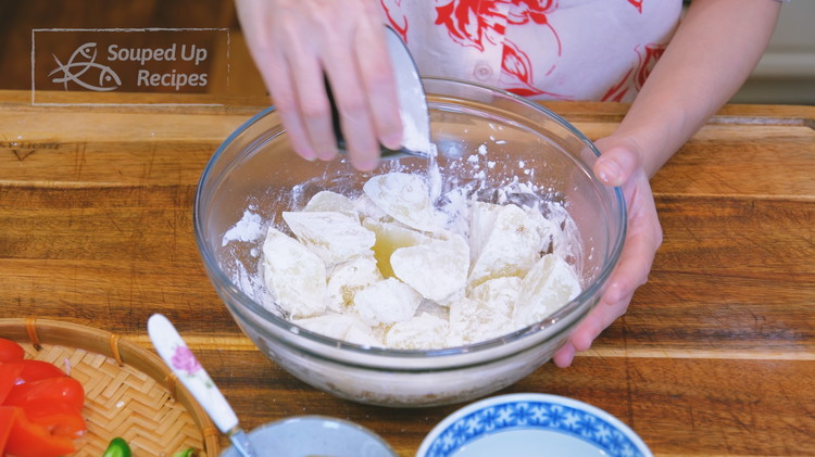 Image of Remove the cooked potatoes from the water and mix with 3 Tbsps cornstarch in a bowl until coated well.