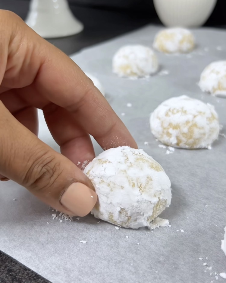 Image of Disposez les boules de pâte sur la plaque de cuisson préparée, en les espaçant correctement. Faites cuire les biscuits dans le four préchauffé pendant environ 10-12 minutes, jusqu'à ce qu'ils soient légèrement dorés et que la surface soit craquelée.