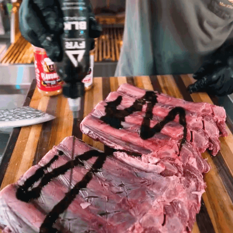 Image of Rub the ribs down with FYR BLK hot sauce to give them a spicy kick and act as a binder.