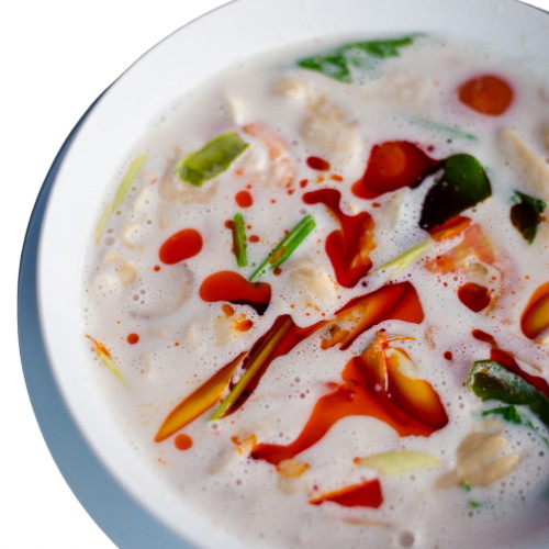 Image of Servieren: Die Tom Kha Gai in eine Schüssel geben, mit geschnittenem Koriander und etwas Chiliöl garnieren, um zusätzliche Schärfe und Aroma hinzuzufügen. Heiß servieren, idealerweise mit gedämpftem Reis.
