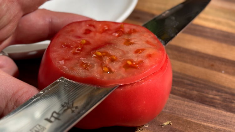 Image of Thinly Slice the Tomato: Using a sharp knife, carefully slice...