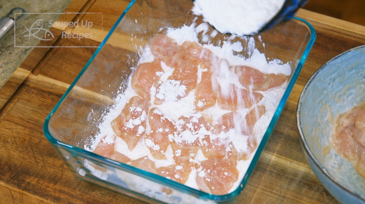 Image of Spread 1/3 of the cornstarch in a big container. Add the marinaded chicken one by one. Sprinkle more cornstarch on the top to cover the chicken. Put on the lid and shake well.