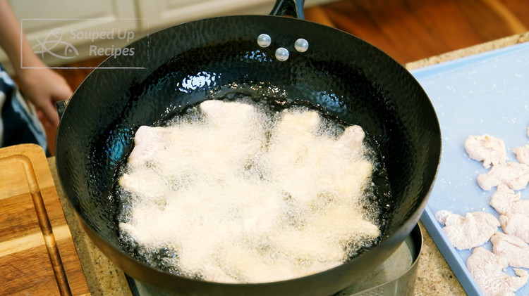 Image of Heat 1.5 cups of oil in a wok to 380 F. Fry the chicken in 2 batches over medium heat, about 3 - 4 minutes for each batch. Use a sieve to eliminate the starch crumbs in between the frying.