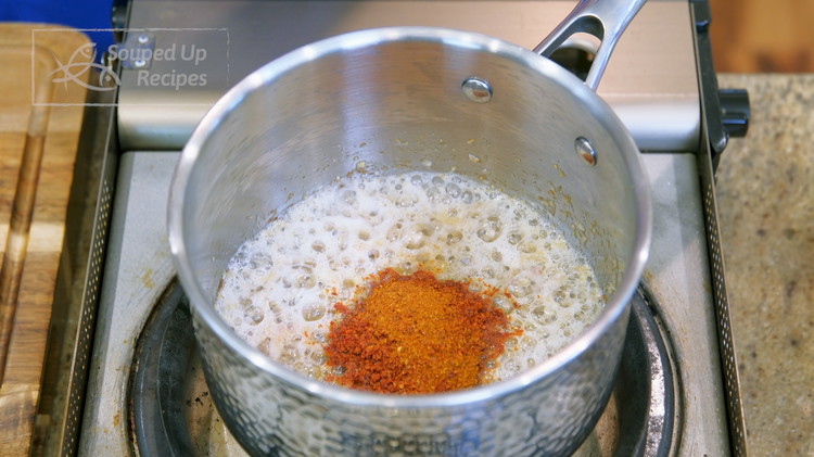 Image of Add the minced aromatics into a sauce pan along with 1 tbsp of cooking oil. Stir over medium heat for a few minutes or until the aromatics are slightly golden on the edge. Add 1 Tbsp of red pepper flake....