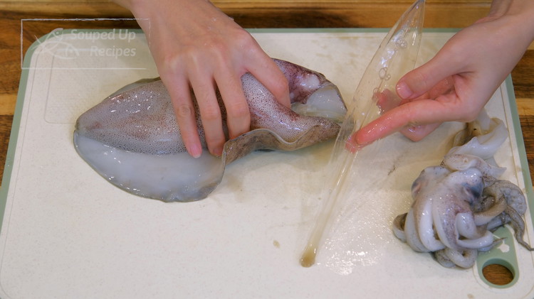 Image of To prepare the squid, separate the head and the body by simply tearing it apart. As you pull, you will also drag the guts out. Discard that. Pull out the transparent quill and discard that as well.