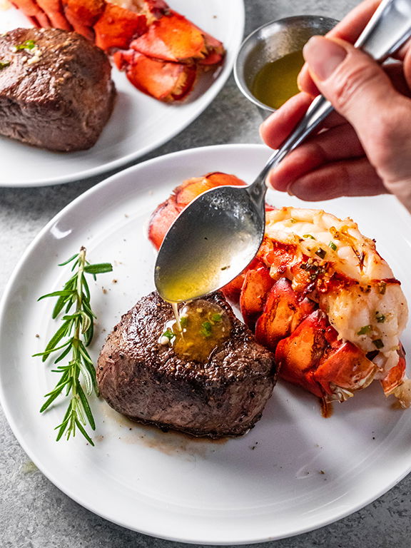 Image of Serve lobster tails and steak with hot herb butter for...