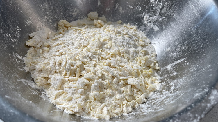 Image of grate the par frozen butter into the flour mix, gently tossing it as you go