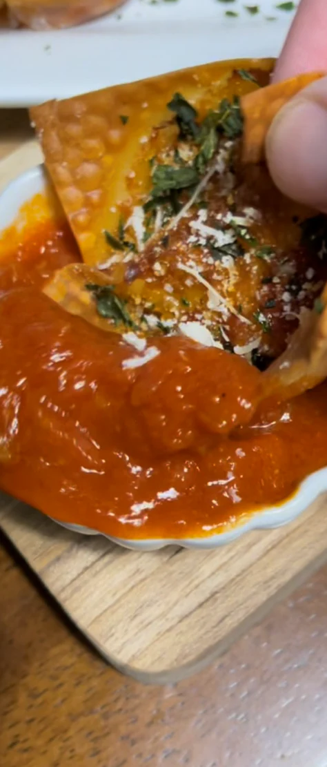 Image of Take your pizza wontons out of the tin. Fill up a small cup of sauce and top with some parsley and parmesan cheese and enjoy! These are the easiest meals I’ve made to date. You can literally prep two batches...