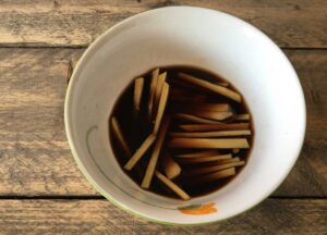 Image of Semplice: tagliate il pezzo di zenzero rimasto a striscioline (julienne) e mescolatelo con l'aceto balsamico e l'aceto di vino. Lasciate riposare per far sviluppare i sapori.