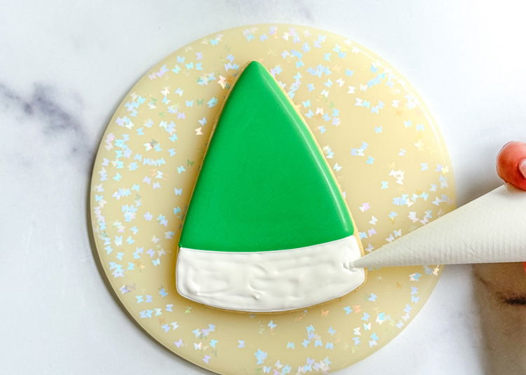 Image of Using the white outline consistency icing, outline and fill in the empty area at the wide end of the wedge shape. Make sure the entire area is filled. The icing does not need to be smooth.  