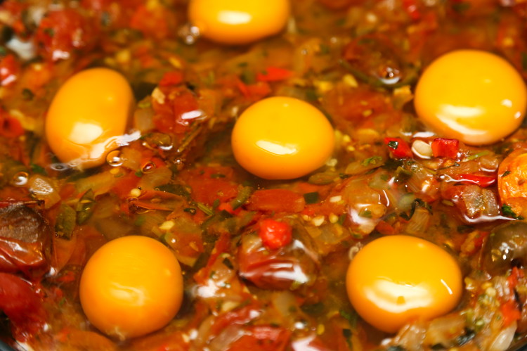 Image of Carefully pull out the baking dish and with a spoon, make 6 wells for your eggs. We want these indentations to help keep the whites and yolks together. We will end up with basically poached/baked eggs. Crack an egg into...