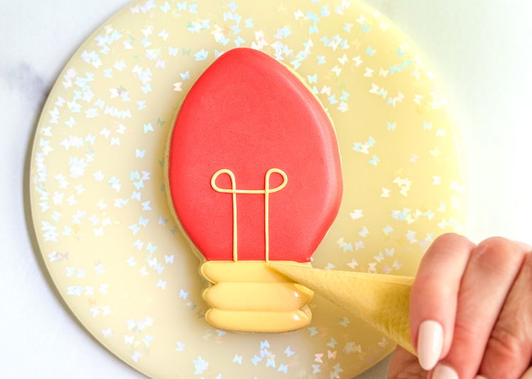 Image of Using the gold outline consistency icing, pipe the final bulb detail to complete your design!  