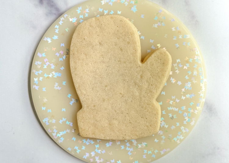 Image of Bake and cool cookies fully before decorating. Prepare royal icing in the following colors and consistencies: dark blue (outline and flood consistencies) and light blue (outline and flood consistencies). Please have a scribe tool or toothpick nearby. Outline/Piping Consistency: Dark Blue Light Blue (Add small amounts of sky blue and bright white gel food coloring to fresh royal icing until a light blue color is achieved) Flood Consistency: Dark Blue Light Blue (Add small amounts of sky blue and bright white gel food coloring to fresh royal icing until a light blue  color is achieved) Pro Tip: This design uses a decorating technique known as “wet-on-wet.” This means we will be moving fairly quickly to add detail to our design while the base flood icing is still wet, rather than waiting for it to dry. I recommend you read through the following steps, to be prepared before starting to decorate. 